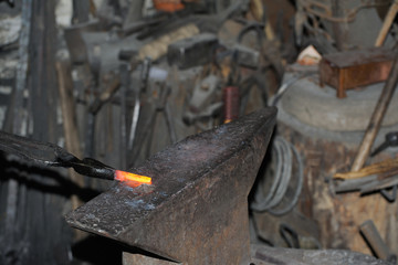 Blacksmith forges a red-hot metal hammer