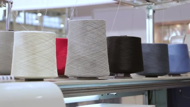 Modern Knitting Loom Machine On Weaving. Automated industrial sewing weaving knitting embroidery loom machine in textile cotton industry production fabric factory. Making clothes underwear.