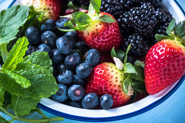 Rustic bowl full of forest summer berry fruits