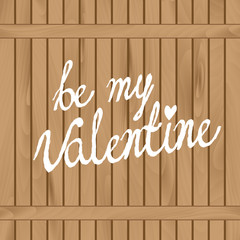 Handwritten text on wooden fence. Phrase "Be my Valentine" painted with white paint. Layered for easy editing.