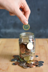 Money or coins in a full jar suggesting home savings