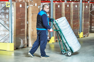 Worker with  delivery cart in warehouse