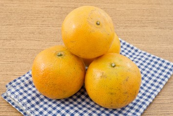 Five Ripe Oranges on A Wooden Table