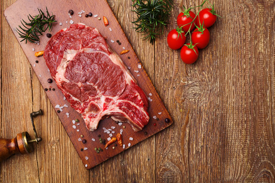 Fresh, raw beef steak on a wooden board