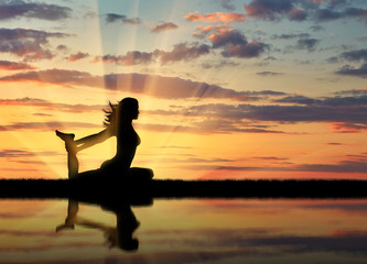 Obraz na płótnie Canvas Silhouette of a girl practicing yoga