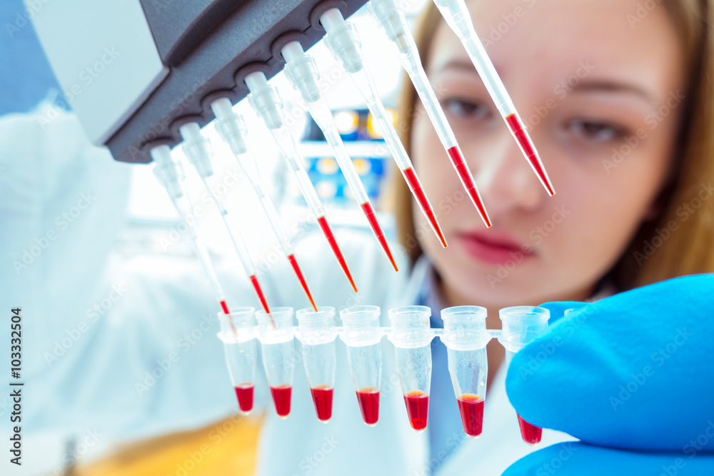 Poster woman assistant in laboratory with multi pipette in the clinic,