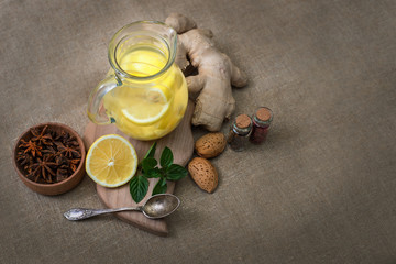 Ginger tea with lemon, ginger root and mint on rustic background
