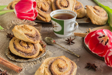 Rolls puff pastry with cinnamon and sugar, tea Cup,flowers