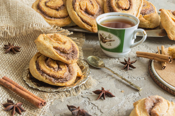 Rolls puff pastry with cinnamon and sugar, tea Cup