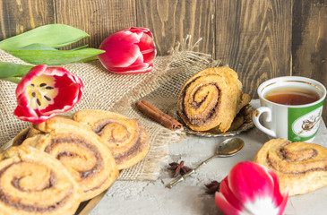 Rolls puff pastry with cinnamon and sugar, tea Cup,flowers
