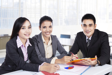 Business team sitting in office and smiling