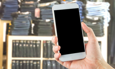 empty blank smartphone in hand with jean denim pants clothes shop background e-commerce business concept