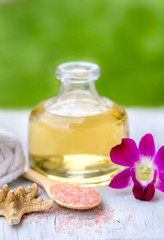 Spa and wellness setting with sea salt, oil essence, flowers and