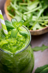 Rucola smoothie, on the grey  background.