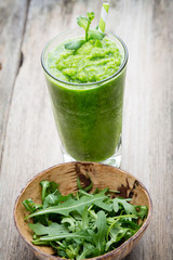 Rucola smoothie, on the grey  background.
