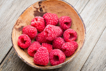 Frozen raspberries on wooden background.