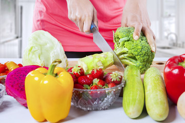 Hand cutting fresh broccoli on the cutting board
