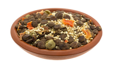 Quinoa and lentil dry soup mix in a small bowl side view isolated on a white background.