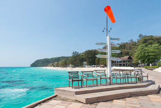 wooden bench and orange wind vane on seaside in Thailand