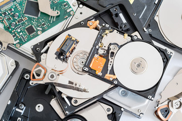 Broken and disassembled parts of a hard disk drives.
