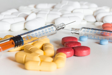medical colored pills and injection on white background