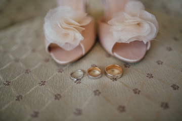 wedding shoes of the bride's delicate skin with wedding rings on