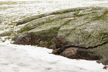 Winter landscape in Finland. Large boulders in the snow covered moss. 