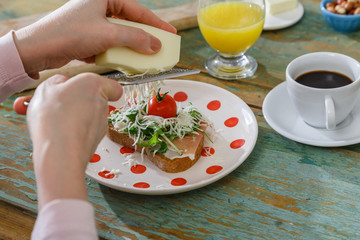 woman gratting chease on to a healthy sandwich