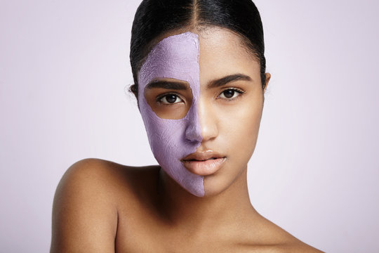 pretty woman with a violet mask on a half of a face
