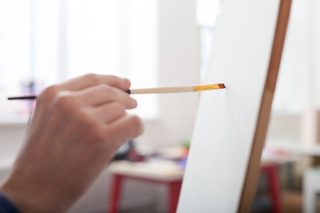 Talented male artist is painting the image