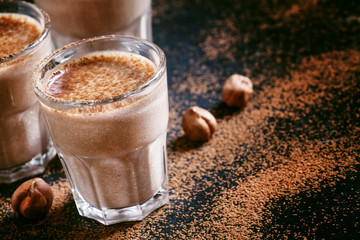 Banana chocolate smoothie with nuts, dusted with a powder, healt