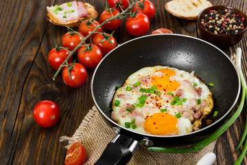 Fried eggs on wooden background.