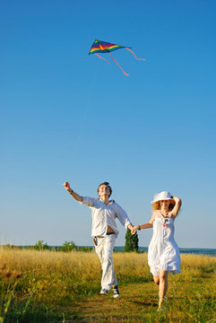 Happy Young Couple Flying A Kite