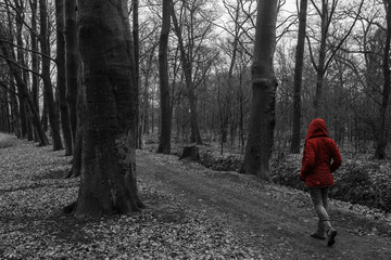 girl walks in the forest with red coat 