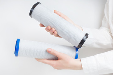 two water filter cartridges in human hands 