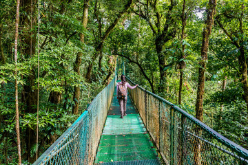 Naklejka premium Girl on hanging bridge in cloudforest - Monteverde, Costa Rica