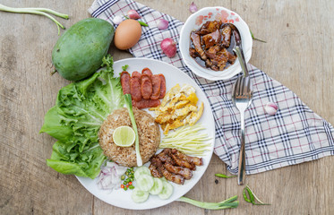 Rice maxed with shrimp paste is Thai Food ingredients are rice, shrimp paste, shallots, chili, fried egg, sweet pork, cucumber, sausage and mango.
