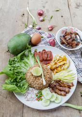 Rice maxed with shrimp paste is Thai Food ingredients are rice, shrimp paste, shallots, chili, fried egg, sweet pork, cucumber, sausage and mango.