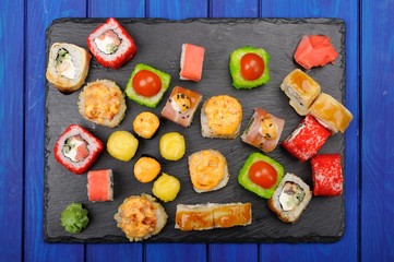 Set of various japanese fusion rolls on black plate flatlay