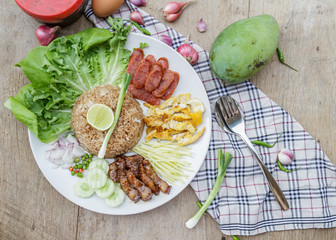 Rice maxed with shrimp paste is Thai Food ingredients are rice, shrimp paste, shallots, chili, fried egg, sweet pork, cucumber, sausage and mango.