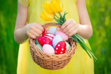 Child holding basket with Easter eggs