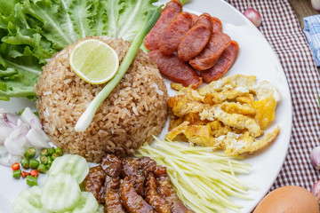 Rice maxed with shrimp paste is Thai Food ingredients are rice, shrimp paste, shallots, chili, fried egg, sweet pork, cucumber, sausage and mango.