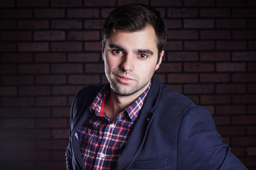Fototapeta premium portrait of handsome man in jacket and plaid shirt