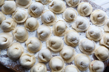 Meat dumplings russian pelmeni on wooden background