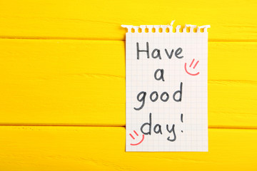 Piece of note paper on yellow wooden background