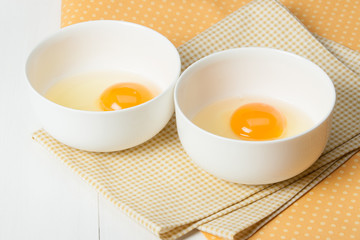 Raw Chicken Eggs In White Bowls On Cotton Napkins