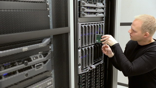 IT technician removes harddrive from blade server in datacenter