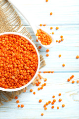 Red lentils in bowl on a blue wooden table