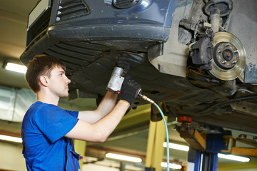 auto mechanic at car suspension repairing