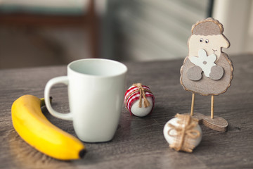 Wood sheep, cup, banan and easter egg on wood table